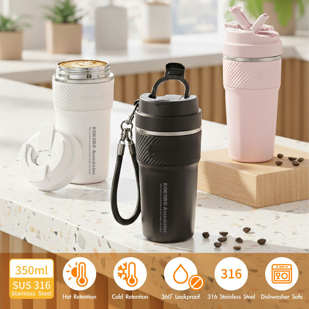 Kokoro Associates branded coffee tumblers in white, black and pink on a kitchen counter