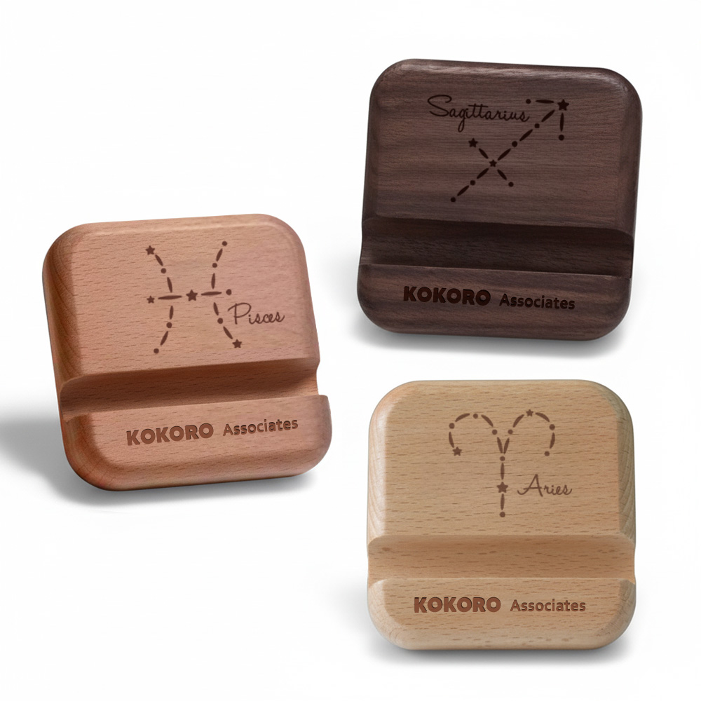 Wooden phone stands engraved with zodiac constellation designs